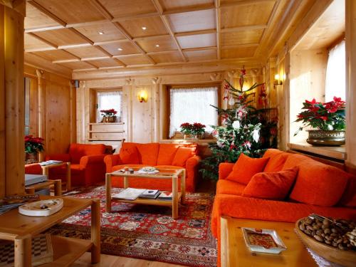 a living room with orange couches and a table at Hotel Natale in Cortina dʼAmpezzo