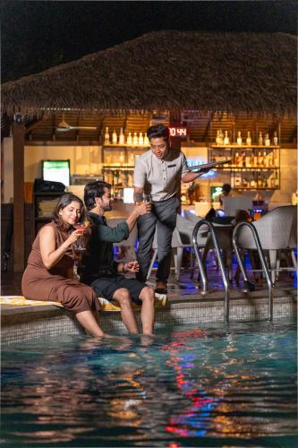 three people sitting in the water at a swimming pool at Fairfield by Marriott Goa Benaulim in Benaulim