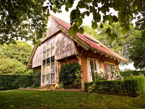 a house with a wooden roof on a lawn at Landgoed De Holtweijde in Lattrop