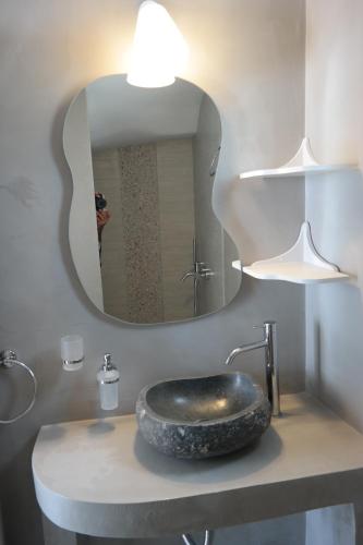 a bathroom with a sink with a large mirror at Maroussa Studios in Agia Anna Naxos