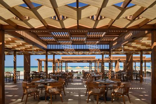 - un restaurant avec des tables et des chaises sur la plage dans l'établissement JAZ Elite Asteria, à Hurghada