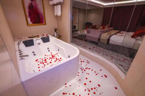 a bathroom with a tub with red hearts on the floor at Cheerful in Unayzah