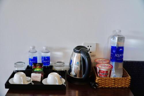 a tray with a tea kettle and bottles of water at The Mira Boutique Hotel in Thu Dau Mot