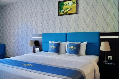 a hotel room with a blue and white bed at The Mira Boutique Hotel in Thu Dau Mot