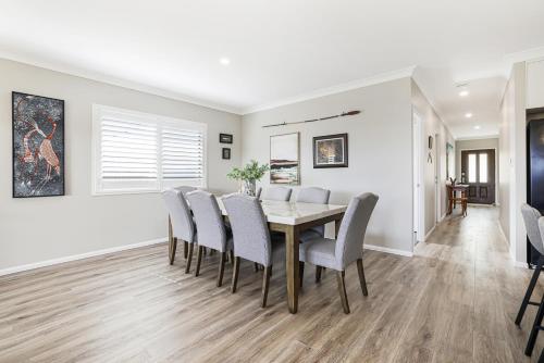 a dining room with a table and chairs at Whitewash House in Bargara