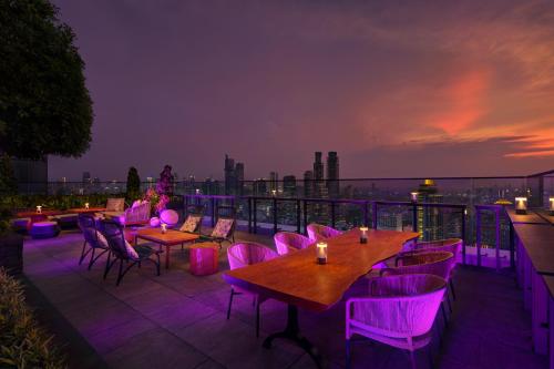 a rooftop patio with tables and chairs and purple lighting at Park Hyatt Jakarta in Jakarta