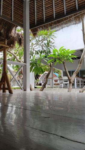 a patio with trees and a table and chairs at Dream CoWork Hotel in Kuta Lombok