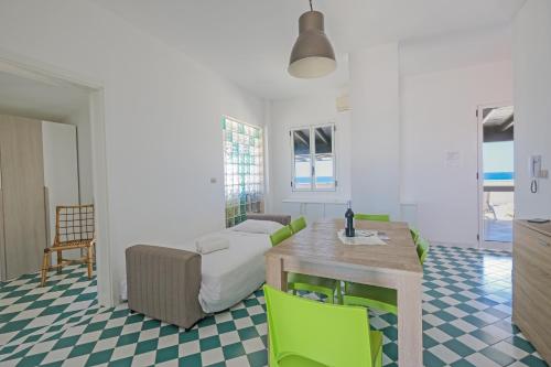 Baia VerdeにあるSea View Penthouse-Atticoのリビングルーム(テーブル、緑の椅子付)