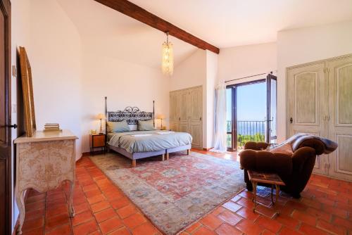 Un dormitorio con una cama y una silla en una habitación. en VILLA les TEMPLIERS, en Vence