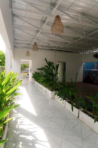 a large room with plants and a ceiling with lights at Dream CoWork Hotel in Kuta Lombok