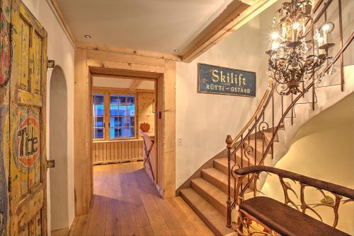 a staircase in a home with a chandelier at Hotel Bären in Gsteig