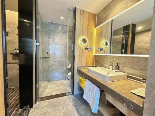 a bathroom with a sink and a shower at 威海市区威高广场万信至格酒店 in Weihai