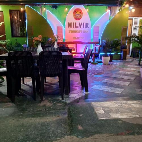 a table and chairs in front of a restaurant at MilVir Tourist INN in El Nido