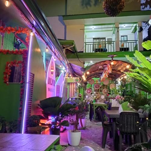 a dining room with a table and purple lights at MilVir Tourist INN in El Nido