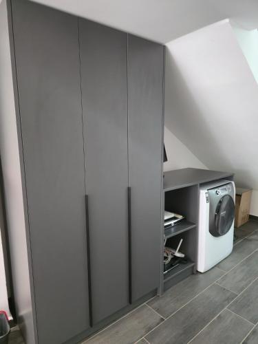a kitchen with gray cabinets and a microwave at Sandy Vibes Apartments in Durrës