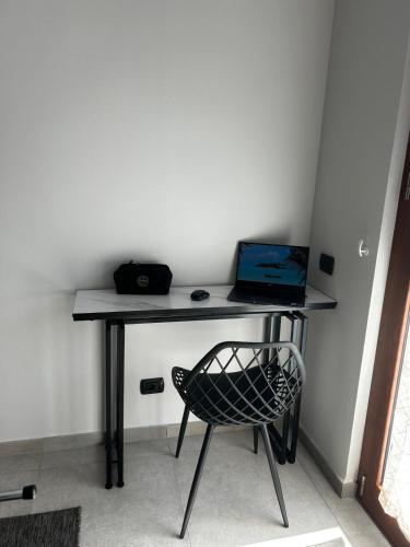 a desk with a laptop and a chair in a room at Casa Neghelli - Alassio in Alassio