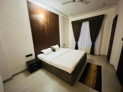 a bedroom with a large bed and a window at The Divine Villa! in Indore