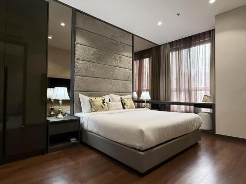 una camera da letto con un letto grande con una grande testiera di 8 Kia Peng KLCC by WSD a Kuala Lumpur