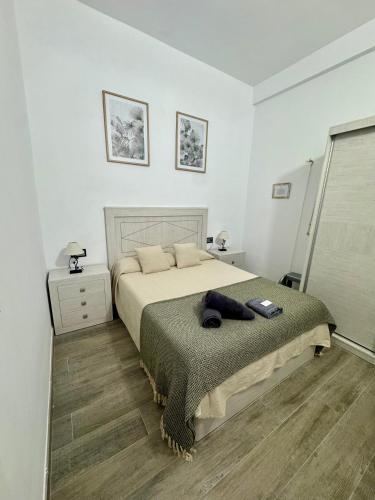 a bedroom with a large bed and a wooden floor at Apartamento Martina 1 in Mérida