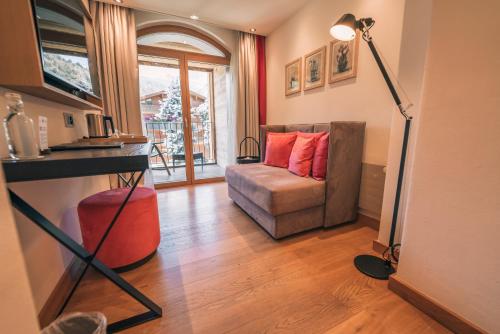 a living room with a couch and a table at Hotel Eden Wellness in Zermatt