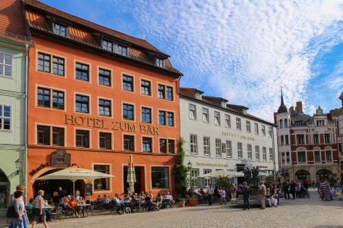 a group of buildings on a street with people sitting outside at Hotel Zum Bär in Quedlinburg