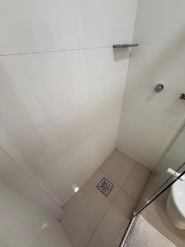 a white shower with a toilet in a bathroom at Apartamento Praia Jacaraípe in Serra