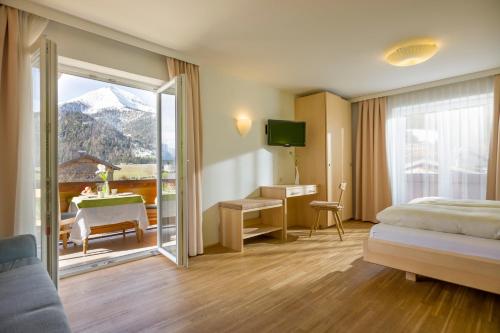 Habitación de hotel con cama y puerta corredera de cristal en BUSSLEHNER Apartments, en Achenkirch