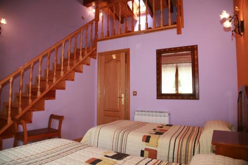 a bedroom with two beds and a staircase at Casa Rural Gaztelubidea in Bernedo