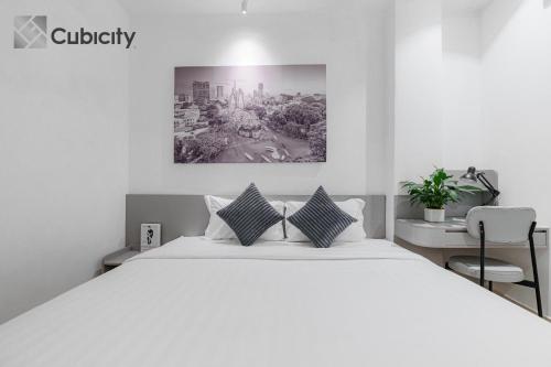 a bedroom with a large white bed with two pillows at Cubicity Walking Street in Ho Chi Minh City