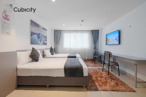 a hotel room with two beds and a desk at Cubicity Walking Street in Ho Chi Minh City