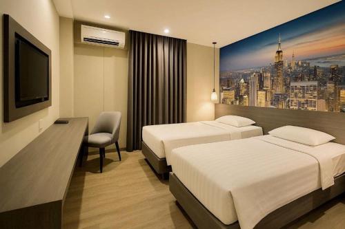 a hotel room with two beds and a television at Plaza Hotel Tegal in Tegal