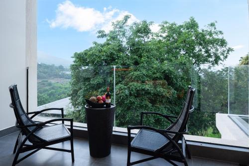 two chairs in front of a window with a tree at Lijiang Jijian Xiangwang SOOOAN Luxury Resort Hotel in Lijiang