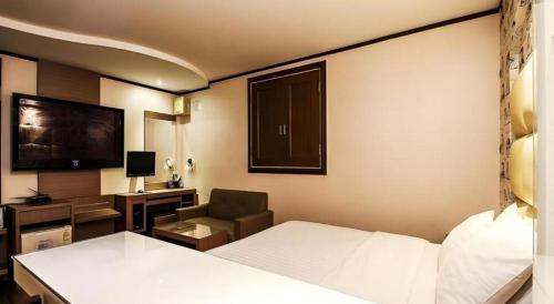 a hotel room with a bed and a chair at Seven Motel Ansan in Ansan