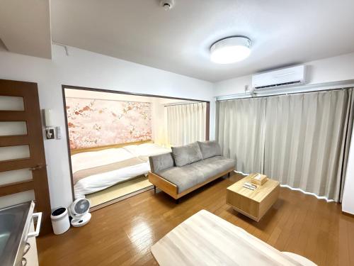 a living room with a couch and a bed at Camelot Home in Fukuoka