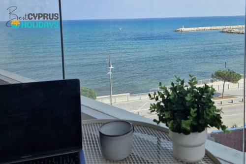 a laptop on a table with a view of the ocean at Seaview City Retreat in Larnaca