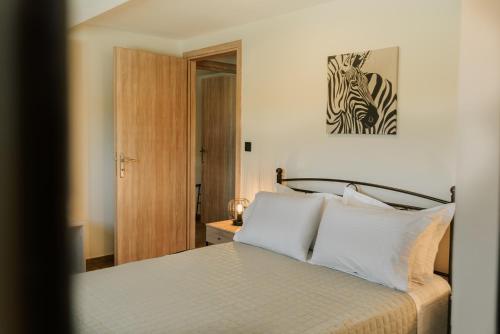 a bedroom with a bed with white pillows at Lotos Families Apartments 5 in Konitsa