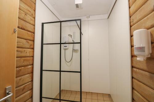 a glass shower in a bathroom with a phone at Shore Lodge Brodick Castle in Brodick