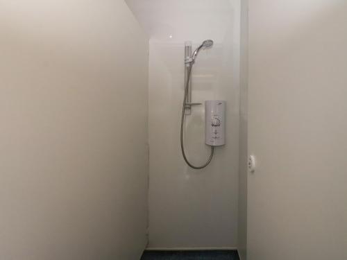 a bathroom with a shower with a phone on the wall at Shore Lodge Brodick Castle in Brodick