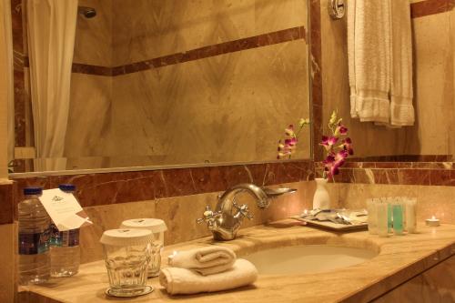 a bathroom counter with a sink and a mirror at Grand Palace Hotel in Amman