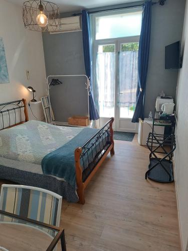 une chambre avec un lit et une grande fenêtre dans l'établissement Chambres d'hôtes les Denias, à Saint-Paul