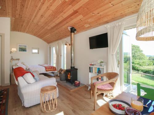 a living room with a white couch and a fireplace at Squirrel's Drey in Bucknell