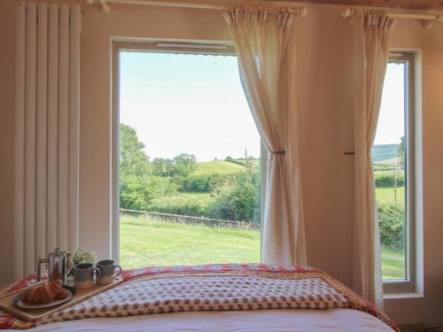 a bedroom with a window with a view of a field at Squirrel's Drey in Bucknell