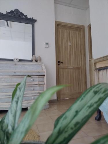 a room with a dresser and a mirror and a plant at Grotta dei Puntali B&B in Carini