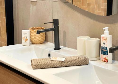 a bathroom sink with a black faucet on it at La Maison Cavet 5 Appartements de standing au cœur du village in Sanary-sur-Mer