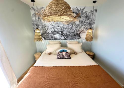 a small room with a bed and a mural at La Maison Cavet 5 Appartements de standing au cœur du village in Sanary-sur-Mer