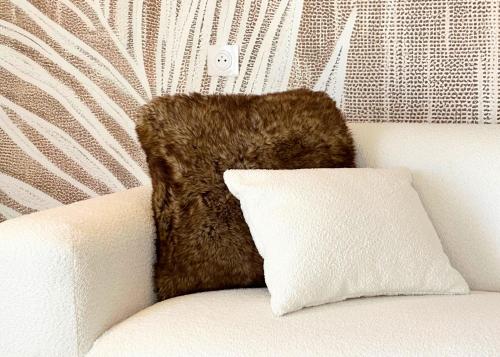 a teddy bear sitting on a couch with a pillow at La Maison Cavet 5 Appartements de standing au cœur du village in Sanary-sur-Mer