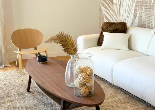 a living room with a coffee table with a glass vase at La Maison Cavet 5 Appartements de standing au cœur du village in Sanary-sur-Mer