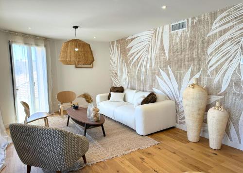 a living room with a white couch and a table at La Maison Cavet 5 Appartements de standing au cœur du village in Sanary-sur-Mer