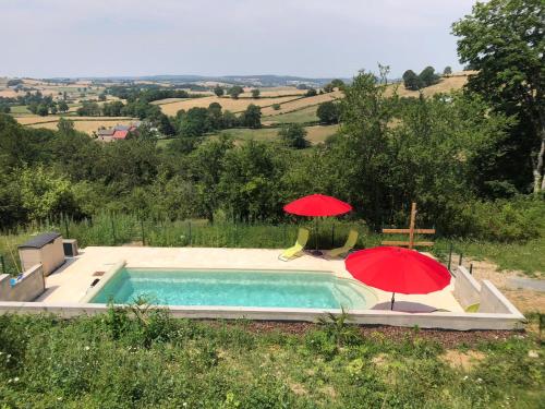 - deux parasols rouges assis à côté d'une piscine dans l'établissement Camping le Faulion, à Cuzy