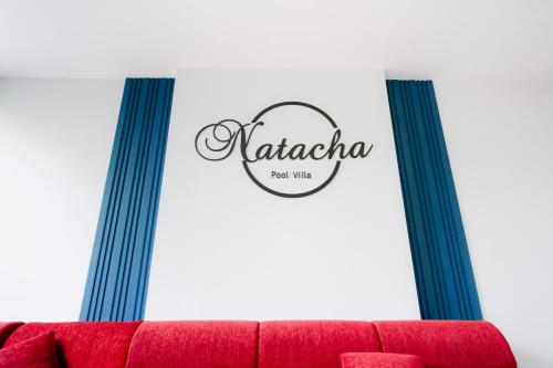 a red couch in a room with two blue stripes at Natacha Pool Villa 2 in Hat Yai Intl